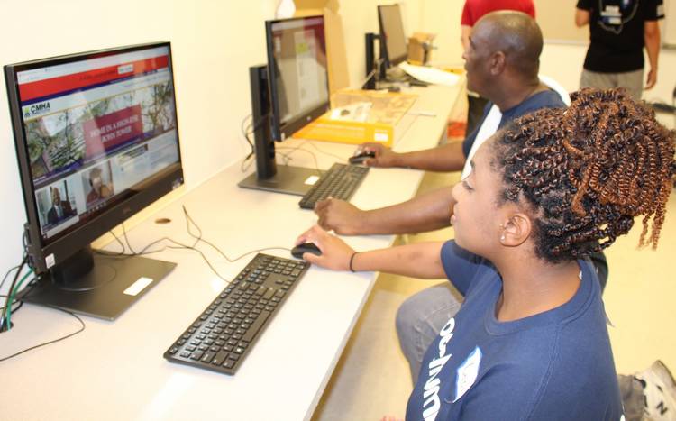 Spectrum volunteers help set up new computers at Lakeview’s Spectrum Training & Technology Center. The center is a place where community members can receive  job skills training for success.